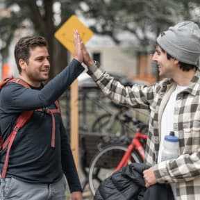 Busbud employees high-fiving during a gathering at the park